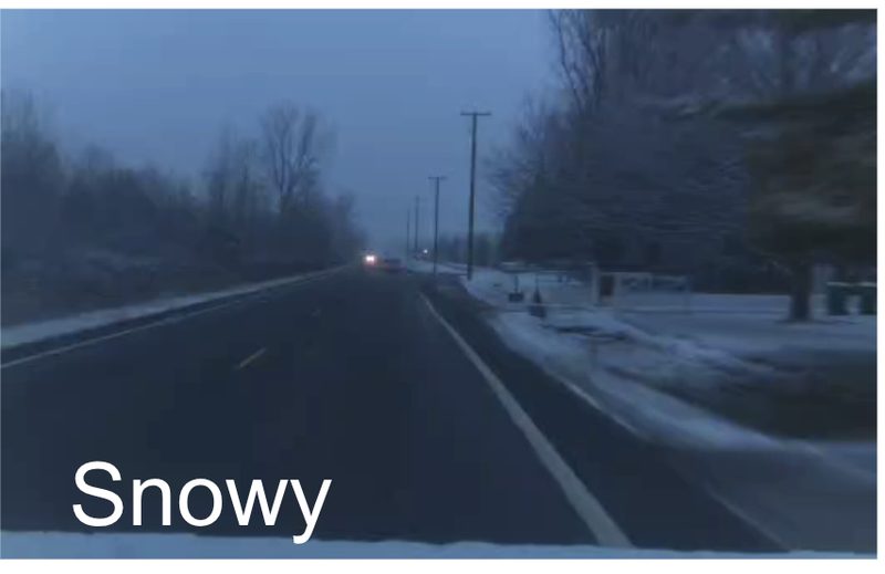 Snow-covered highway at dusk with the lane lines buried